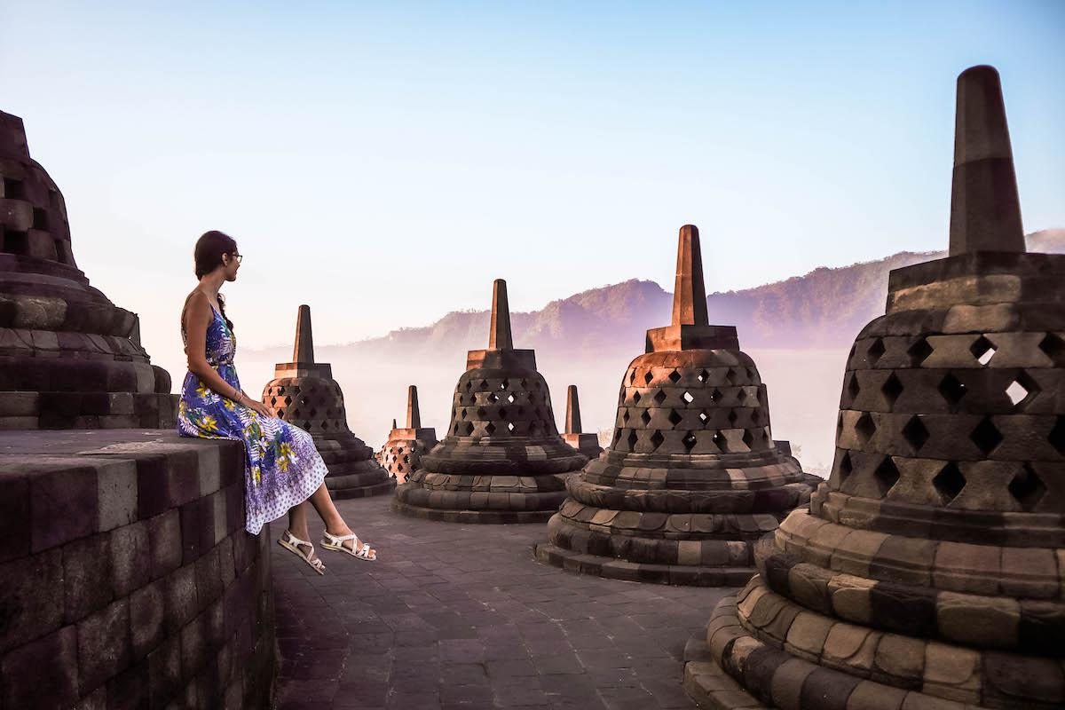 Visitors walking through the corridors of Borobudur, admiring the historical and architectural beauty. 