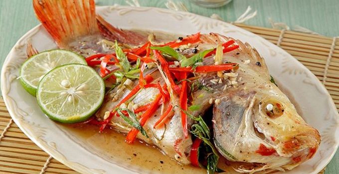 Ikan nila kukus dengan taburan bawang putih dan jahe, disajikan hangat dengan aroma yang menggoda