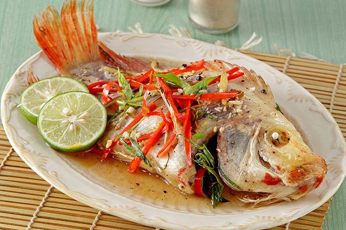 Ikan nila kukus dengan taburan bawang putih dan jahe, disajikan hangat dengan aroma yang menggoda