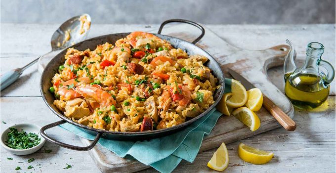 Close-up of a traditional Spanish paella showcasing perfectly cooked rice, juicy seafood, and fresh parsley