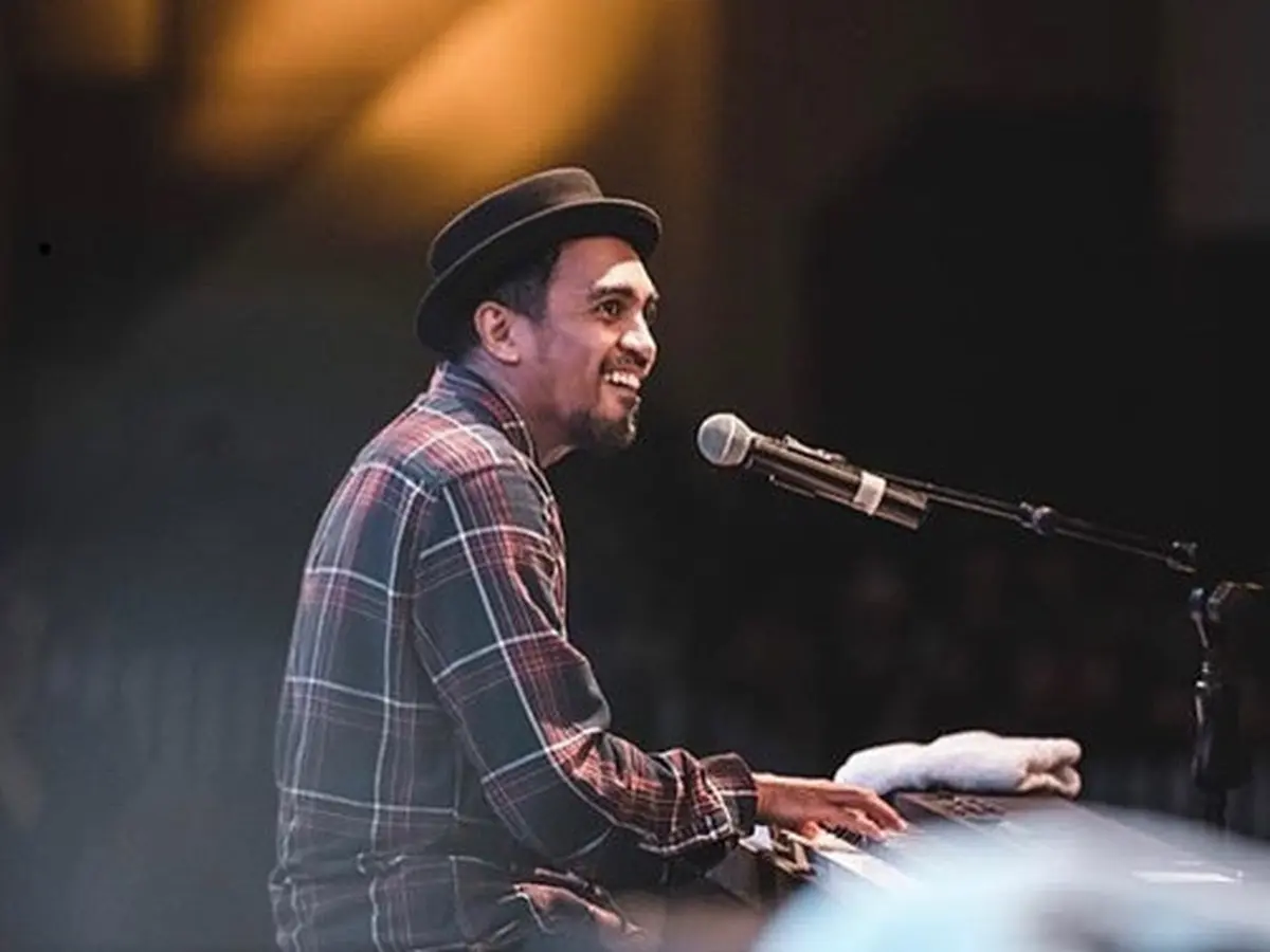 Potret Glenn Fredly sedang menyanyikan lagu dengan penuh emosi di atas panggung
